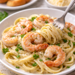 Creamy shrimp fettuccine Alfredo served in a white bowl, garnished with parsley and Parmesan.